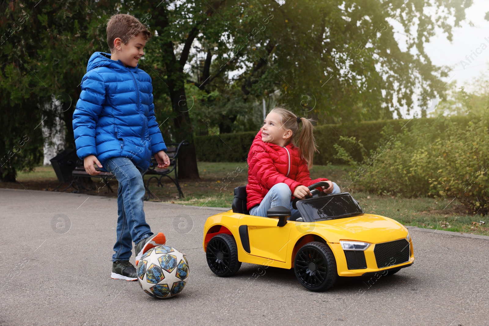Photo of Cute little children with toy car and soccer ball having fun outdoors
