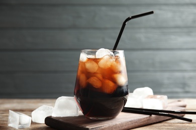 Photo of Composition with glass of refreshing cola on table