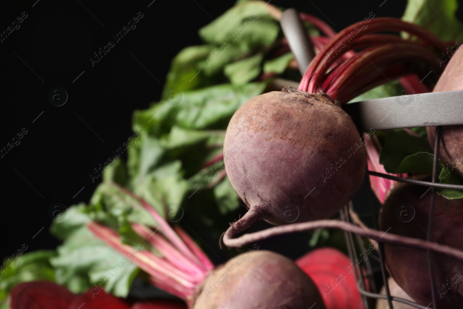 Photo of Whole ripe beets on black background, closeup