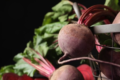 Photo of Whole ripe beets on black background, closeup