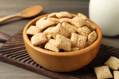 Photo of Bowl of delicious corn pads on wooden table, closeup