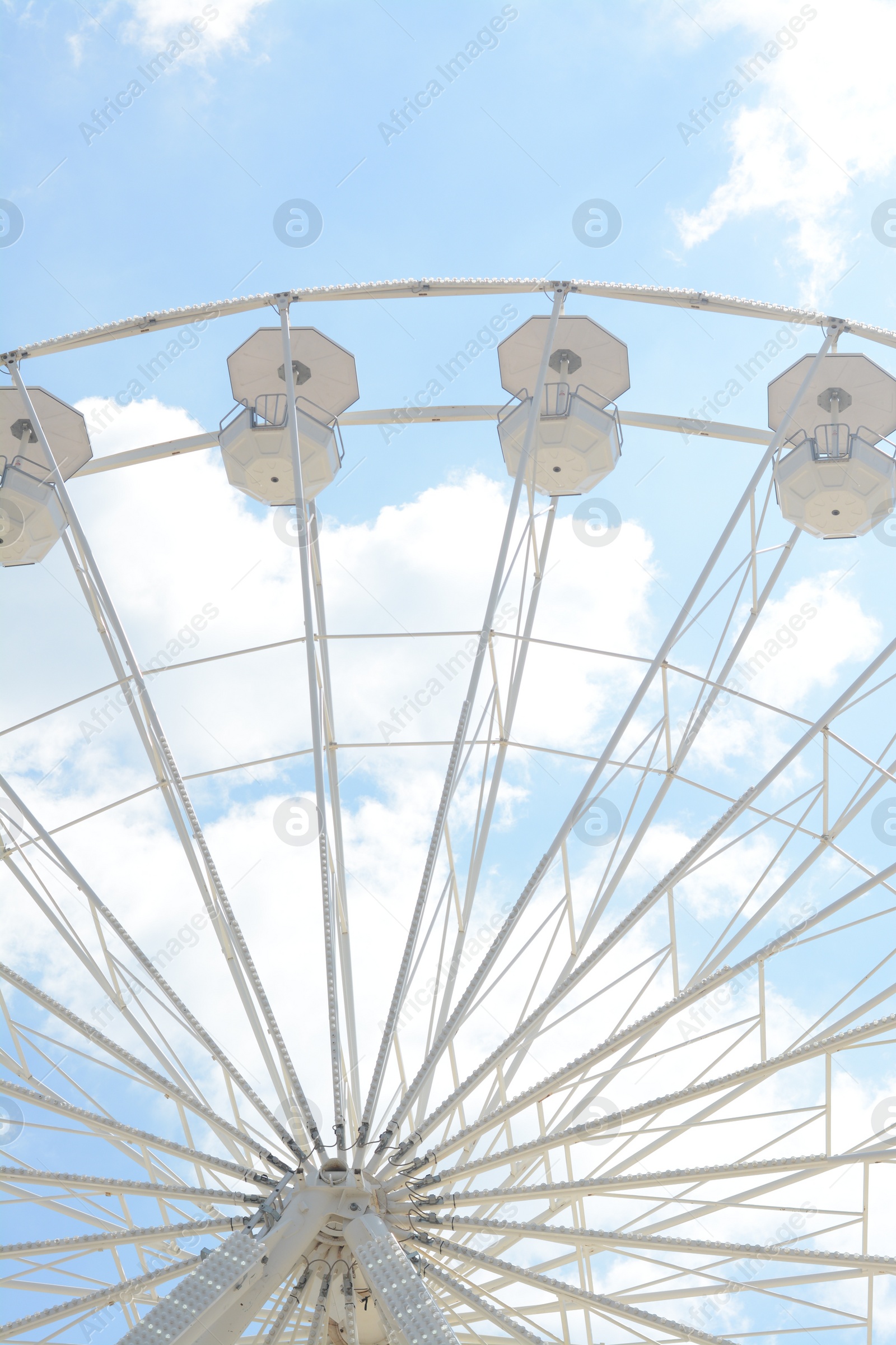 Photo of Large observation wheel against blue cloudy sky, low angle view