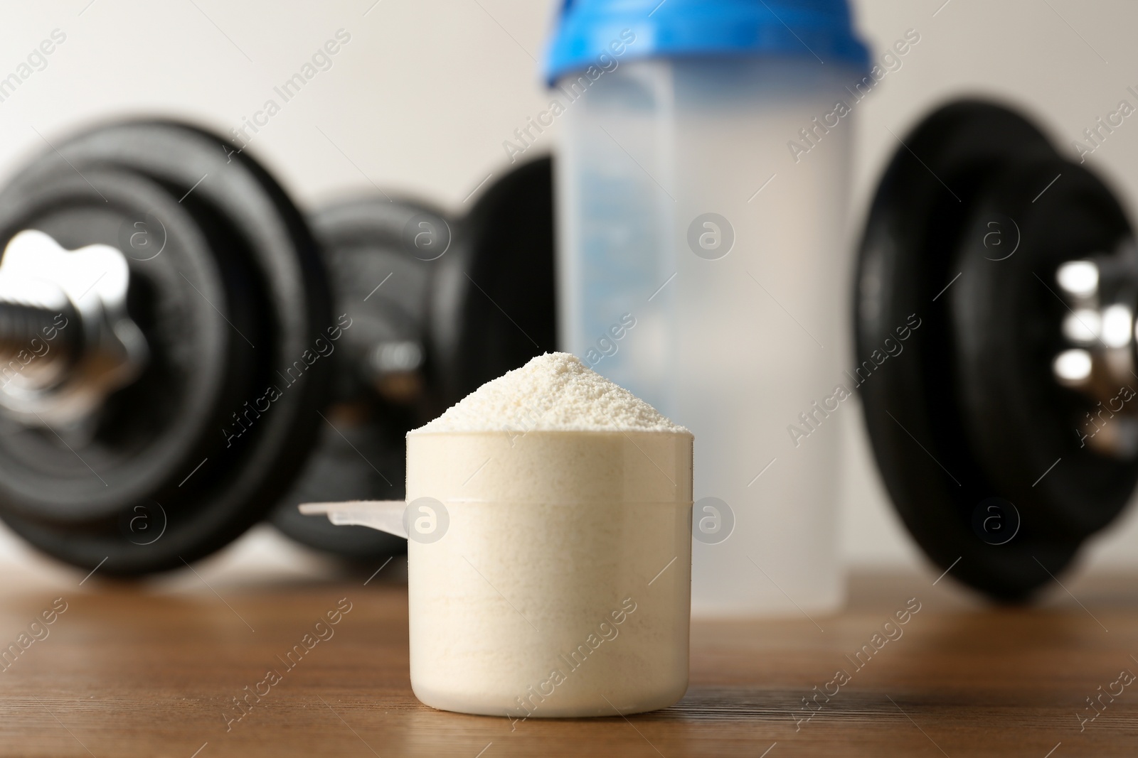 Photo of View of scoop with protein shake powder on table, closeup