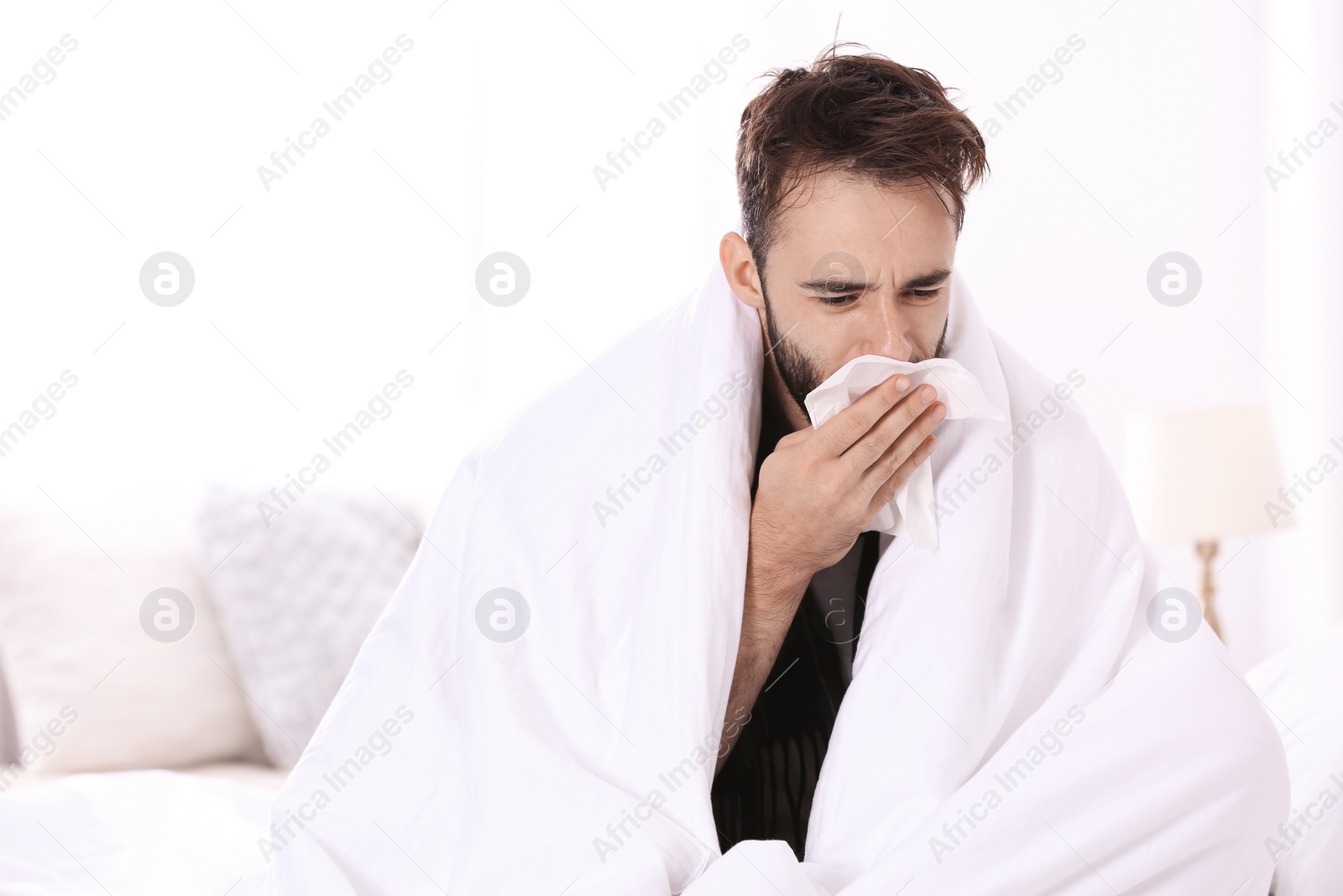 Photo of Ill man suffering from cough at home