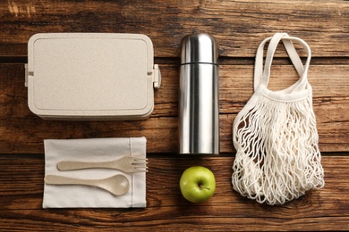 Photo of Flat lay composition with thermos and lunch box on wooden background