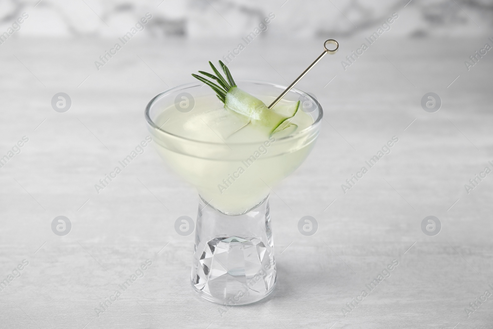Photo of Glass of tasty cucumber martini on grey table