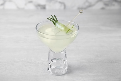 Glass of tasty cucumber martini on grey table