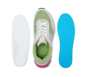 Photo of Different orthopedic insoles near shoe on white background, top view