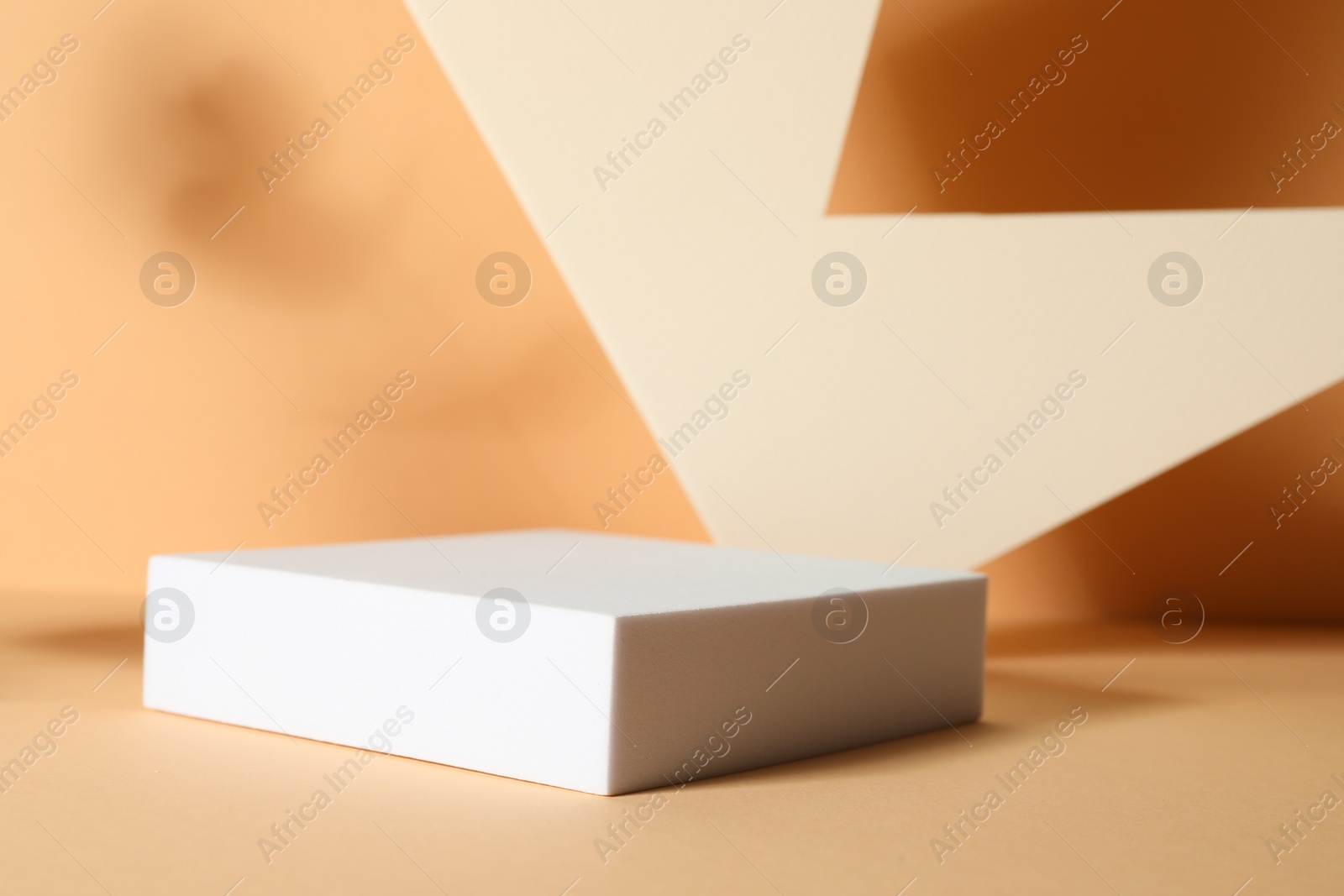 Photo of Presentation of product. Podium and paper on orange background