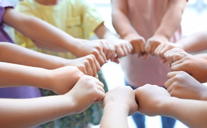 Photo of Little children putting their hands together, closeup. Unity concept