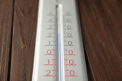 Photo of Modern weather thermometer on wooden background, closeup