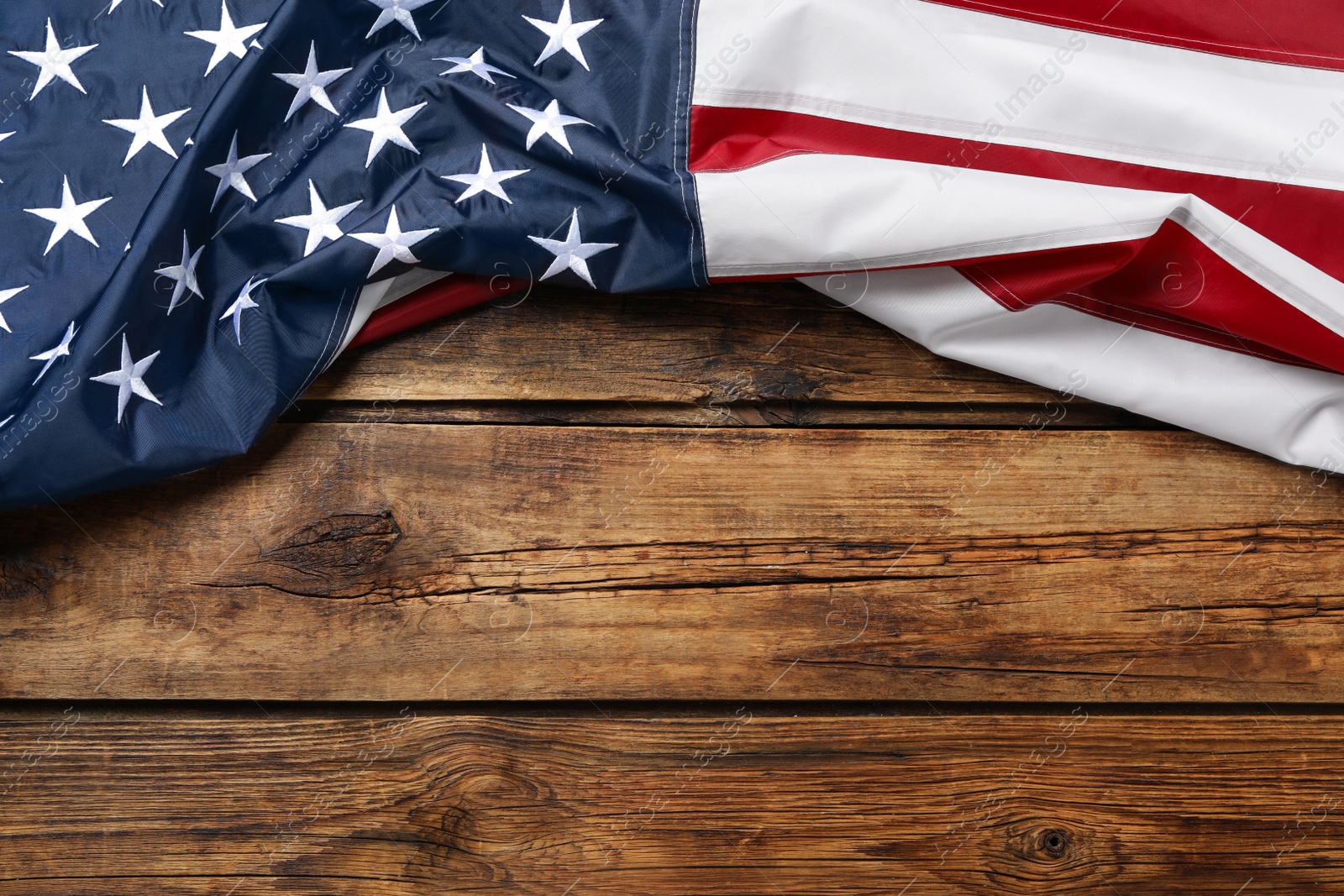 Photo of American flag on wooden table, top view with space for text. Memorial Day