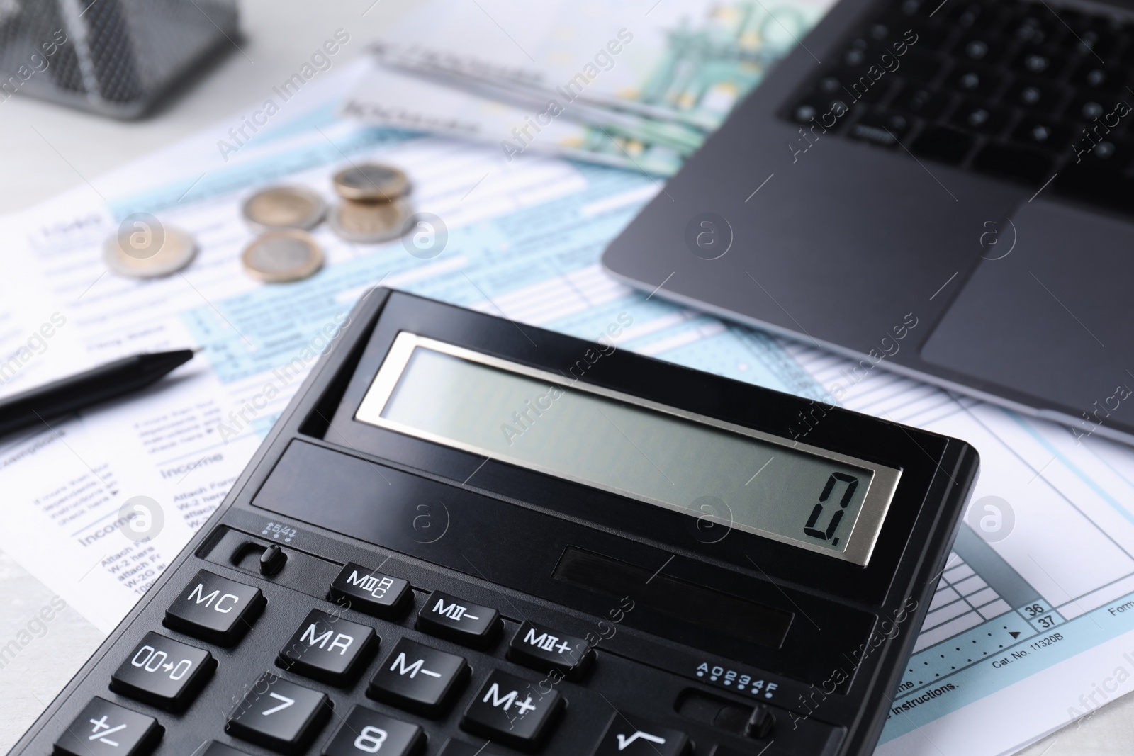 Photo of Tax accounting. Calculator, documents, laptop and money on table, closeup