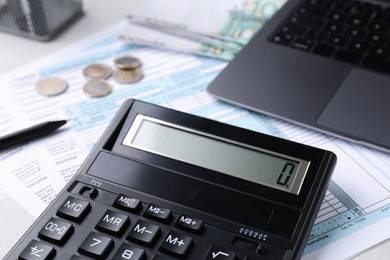 Photo of Tax accounting. Calculator, documents, laptop and money on table, closeup