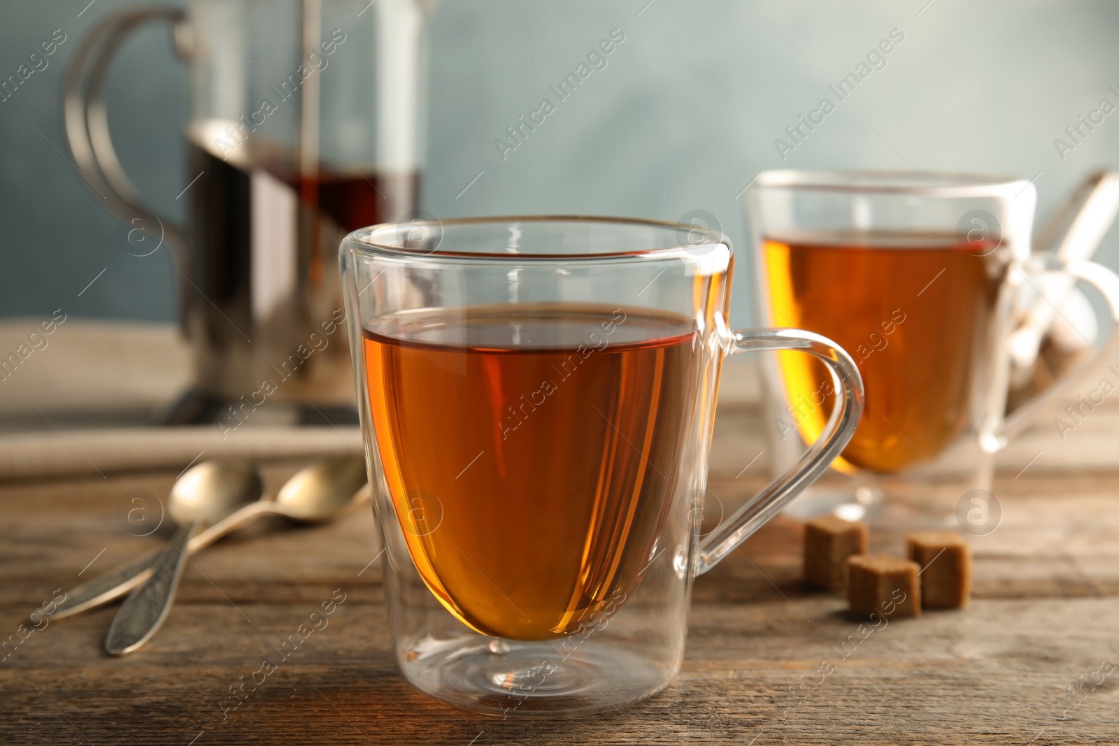 Photo of Glass cups with black tea on wooden table