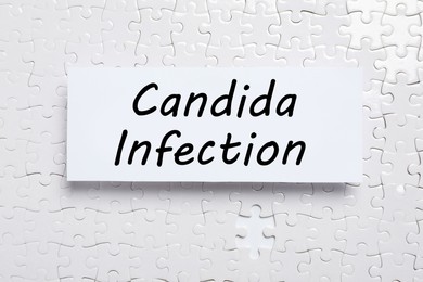 Image of Card with phrase Candida Infection on white puzzle pieces, top view
