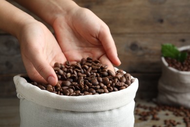 Woman taking roasted coffee beans from bag, closeup