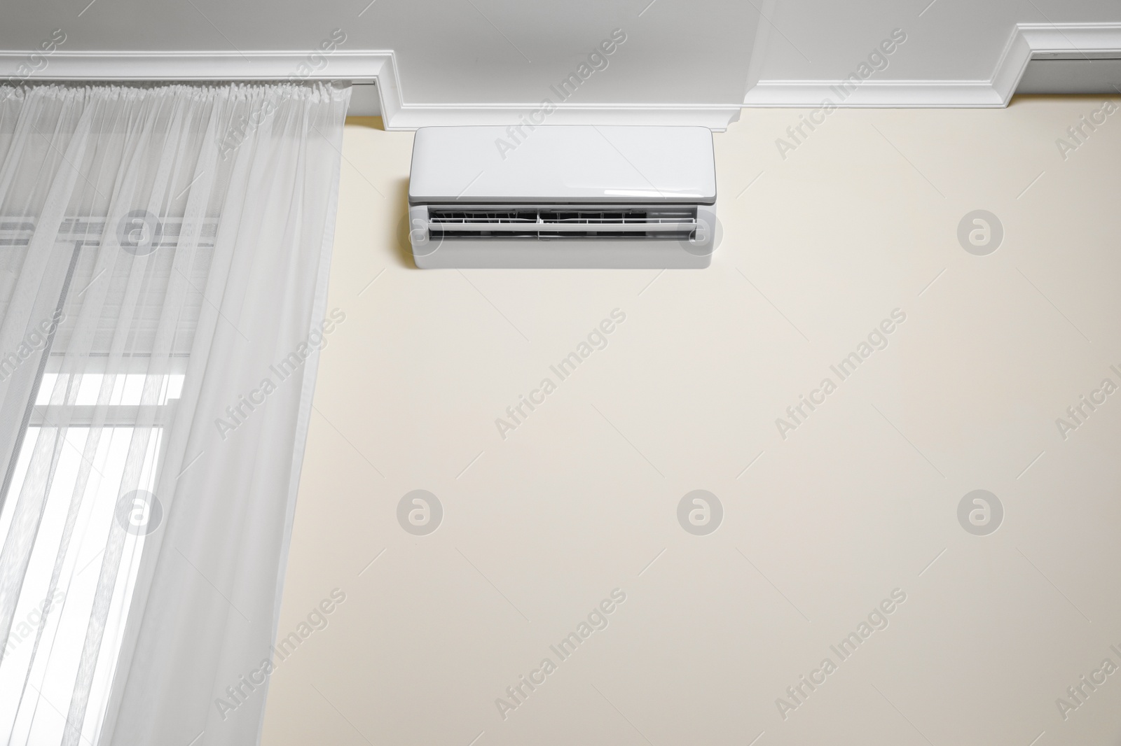 Photo of Modern air conditioner on white wall indoors