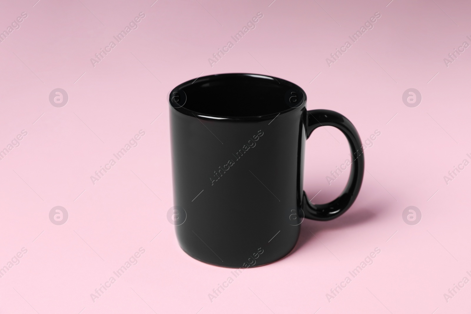 One black ceramic mug on pink background Photo of One black ceramic mug on pink background