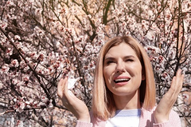 Woman suffering from seasonal allergy outdoors on sunny day