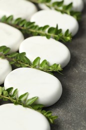 Photo of Spa stones and branches of plant on grey table, closeup