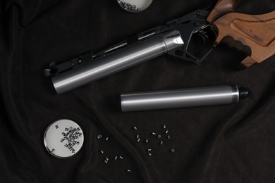 Photo of Gun shooting sport. Standard pistol and ammunition on dark fabric, flat lay