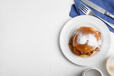 Photo of Delicious pancakes with maple syrup, sugar powder and fried bacon on white table, flat lay. Space for text
