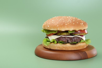 Photo of Burger with delicious patty on green background. Space for text