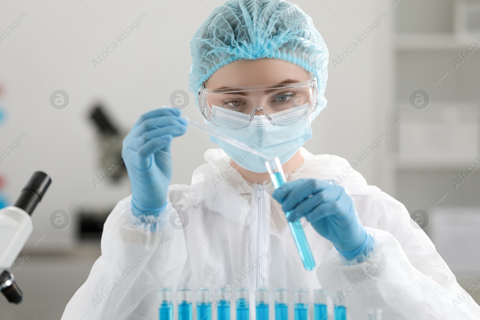 Photo of Scientist dripping sample into test tube in laboratory