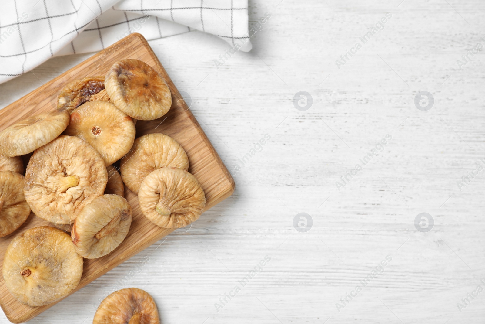 Photo of Tasty dried figs on white wooden table, flat lay. Space for text