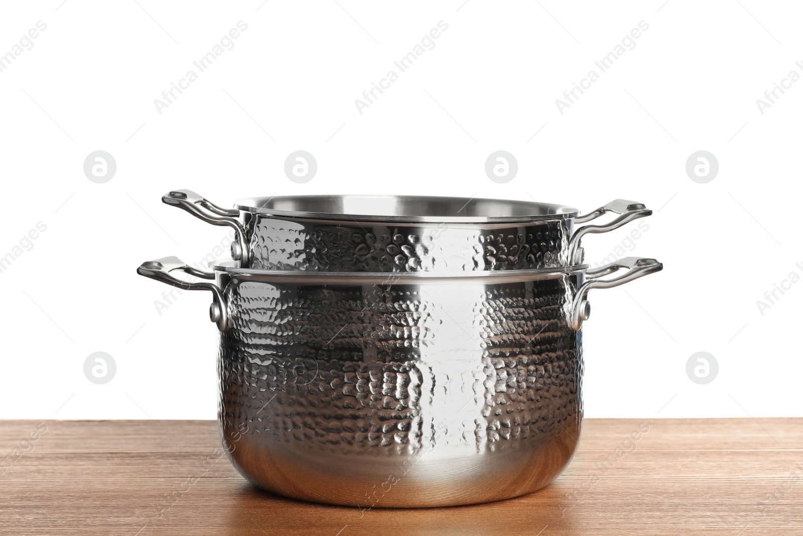 Photo of Stack of clean saucepans on table against white background