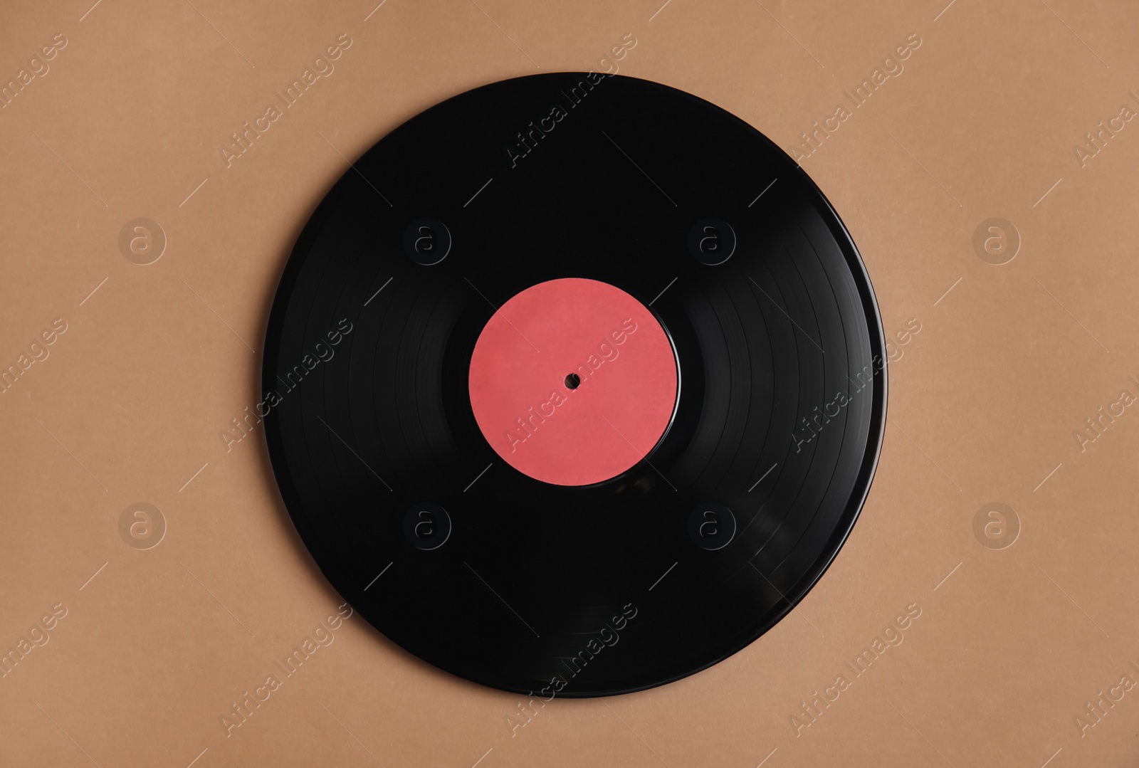 Photo of Vintage vinyl record on brown background, top view