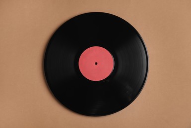 Photo of Vintage vinyl record on brown background, top view
