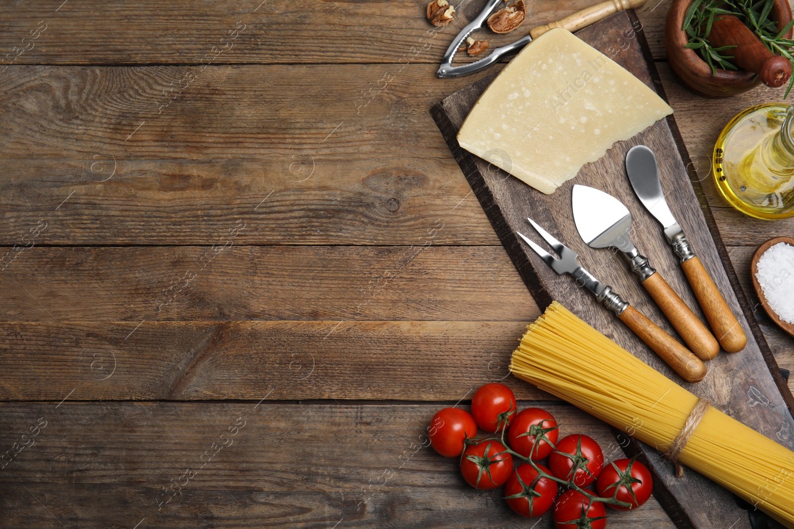 Photo of Flat lay composition with cooking utensils and fresh ingredients on wooden table. Space for text