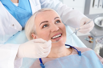 Dentist examining patient's teeth in modern clinic