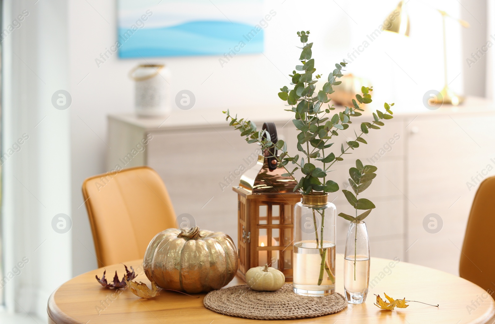 Photo of Beautiful living room interior with eucalyptus branches and decor on table