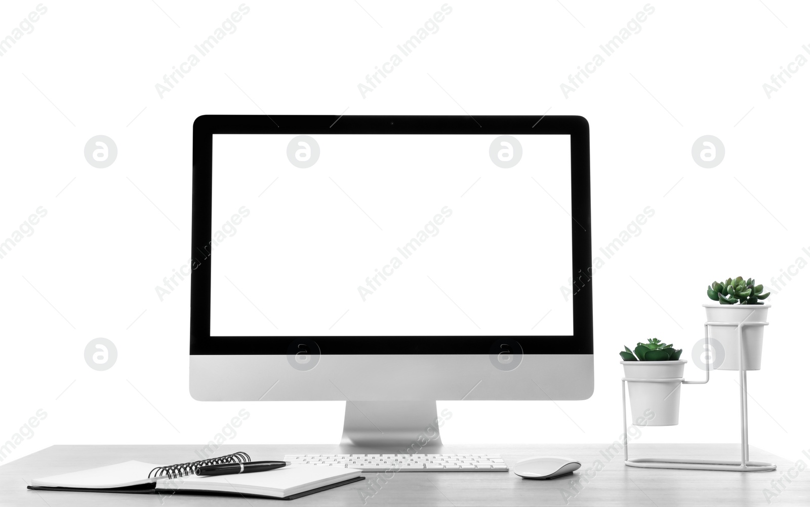 Photo of Computer, potted plants and notebook on table against white background. Stylish workplace