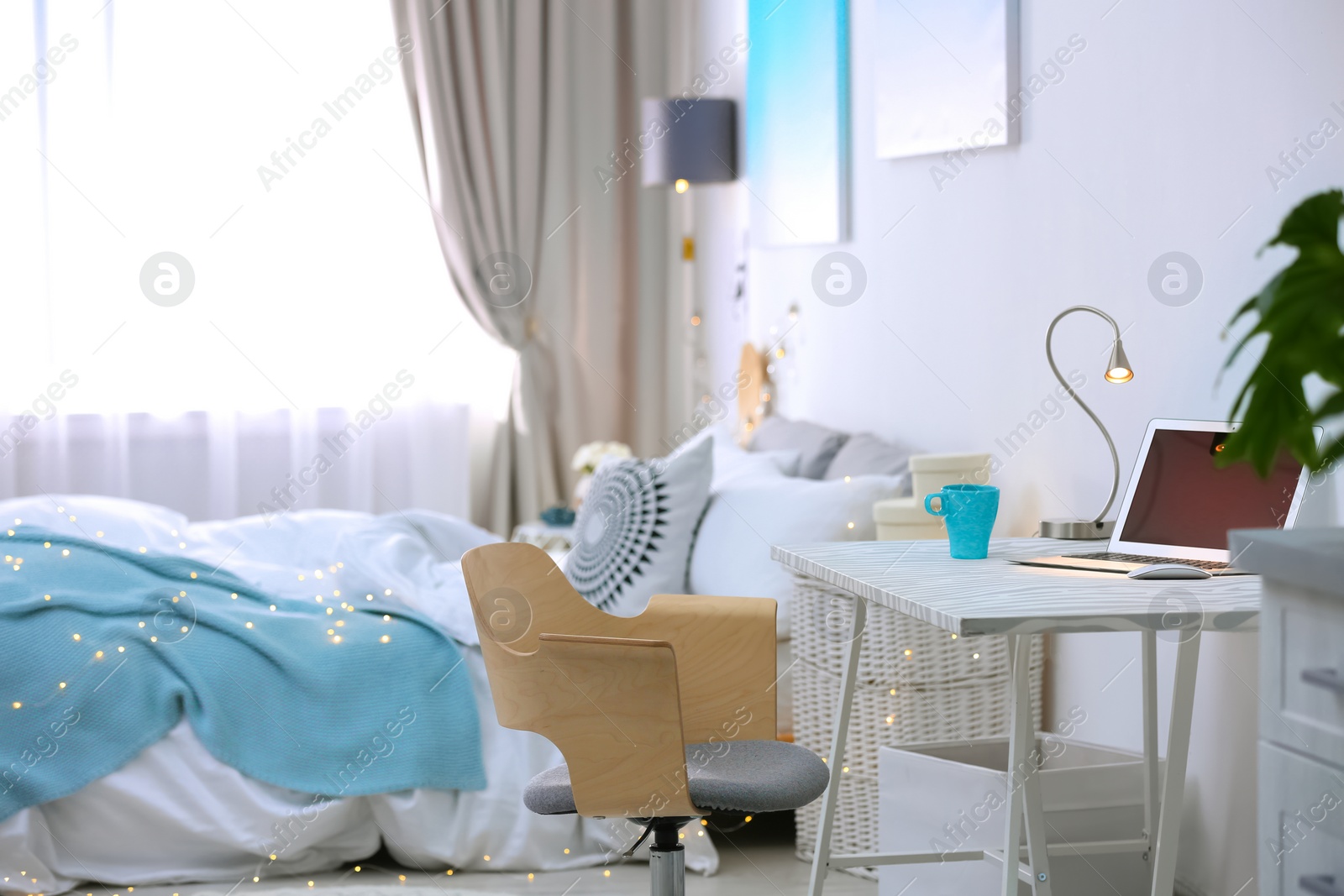 Photo of Stylish room interior with comfortable bed and workplace