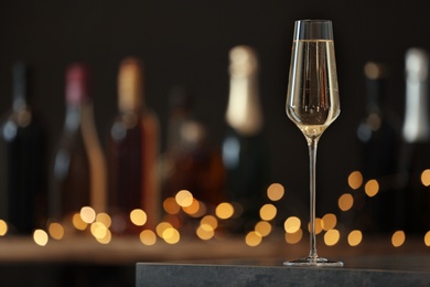 Glass of champagne on table against blurred background. Space for text