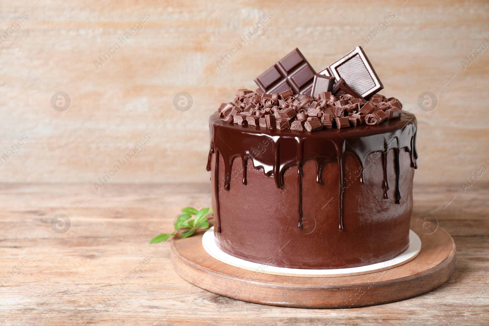 Photo of Freshly made delicious chocolate cake on wooden table. Space for text