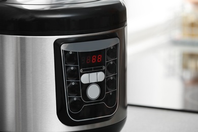 Photo of Modern electric multi cooker on table, closeup. Space for text