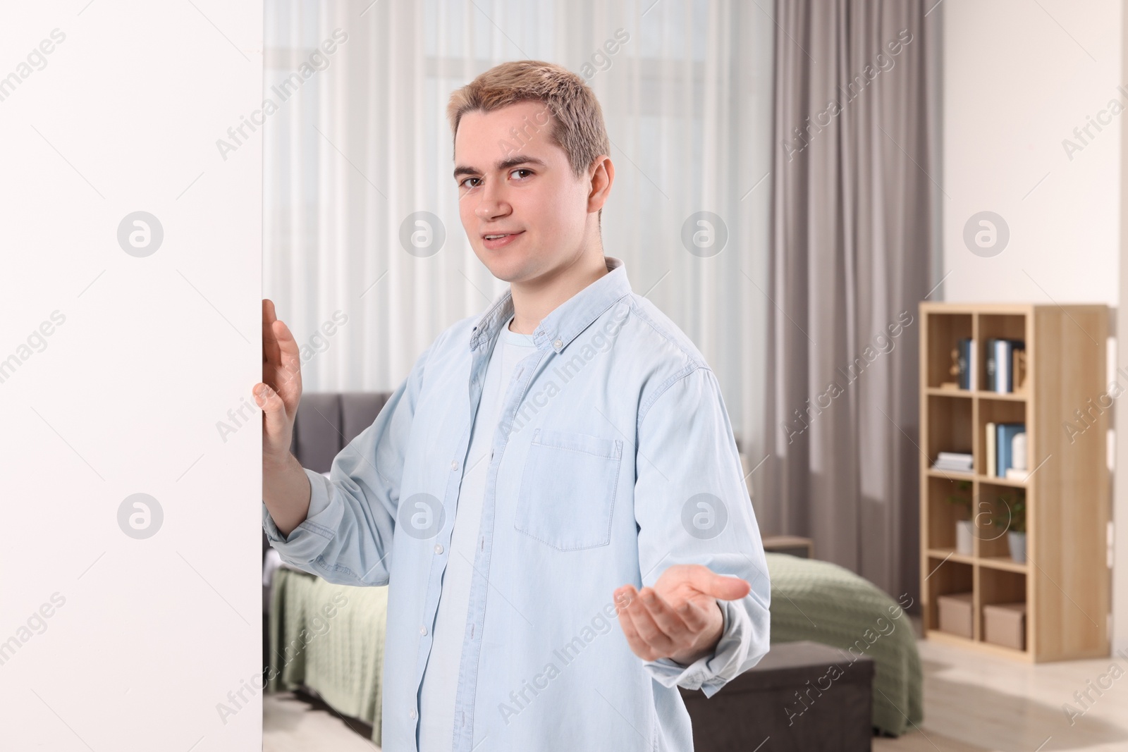 Photo of Happy man inviting to come in room