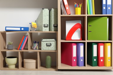 Colorful binder office folders and other stationery on shelving unit