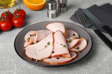 Photo of Delicious cut ham with thyme and peppercorns served on light grey table