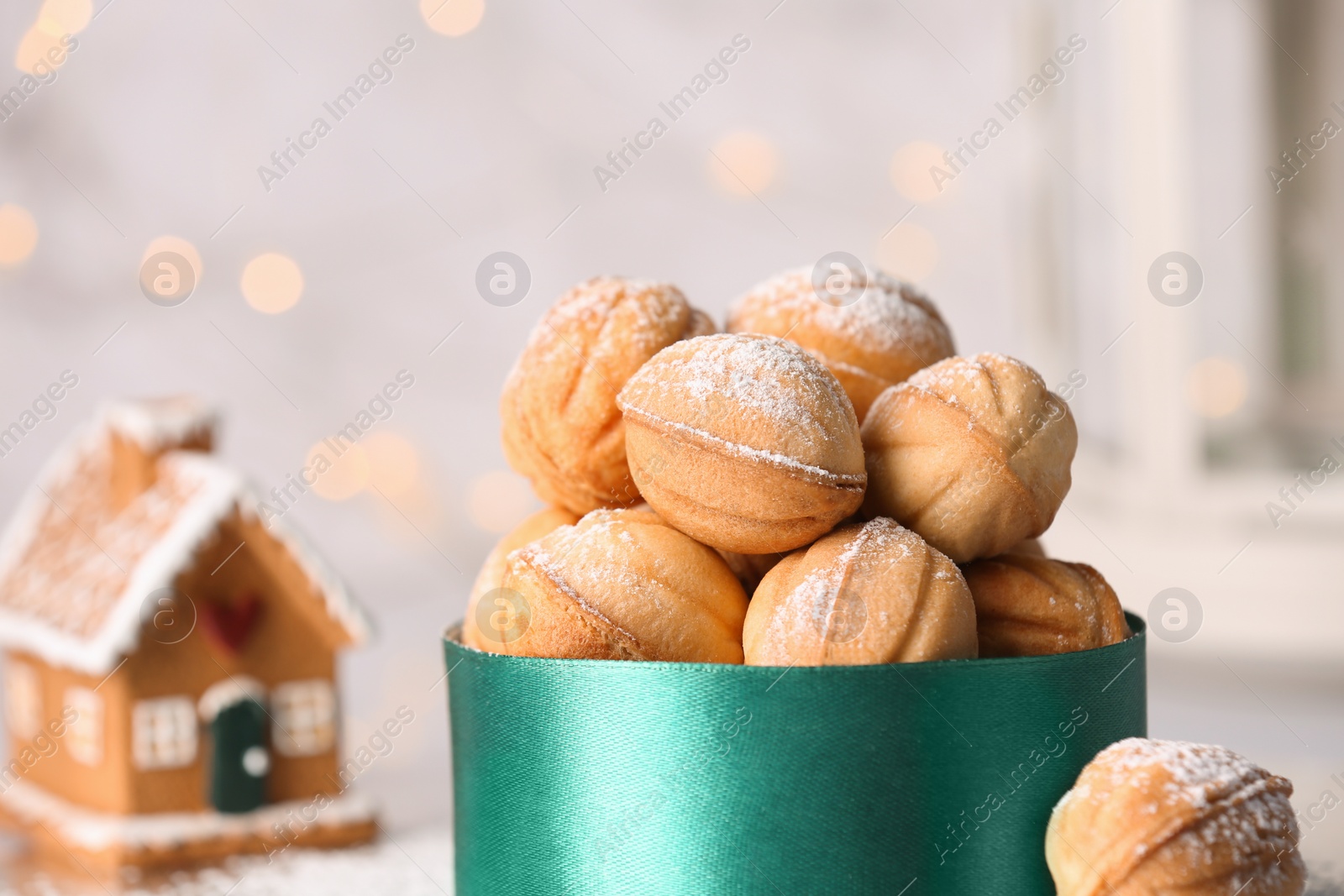 Photo of Box with delicious nut shaped cookies on blurred background, closeup