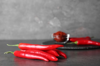 Ripe hot chili peppers on grey table