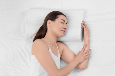 Photo of Woman sleeping on orthopedic pillow in bed