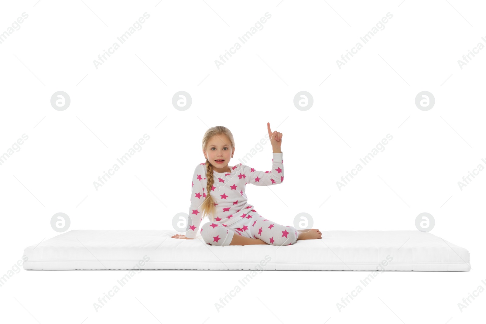 Photo of Little girl sitting on mattress against white background