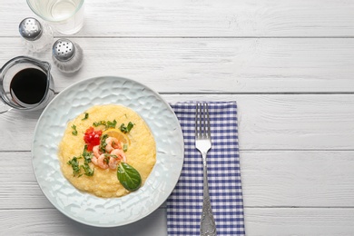 Plate with tasty shrimps and grits on table, top view