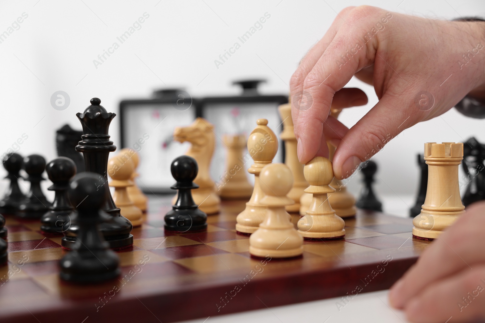 Photo of Man playing chess at table indoors, closeup